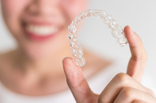 A girl holding her Invisalign Aligner A girl holding her Invisalign Aligner