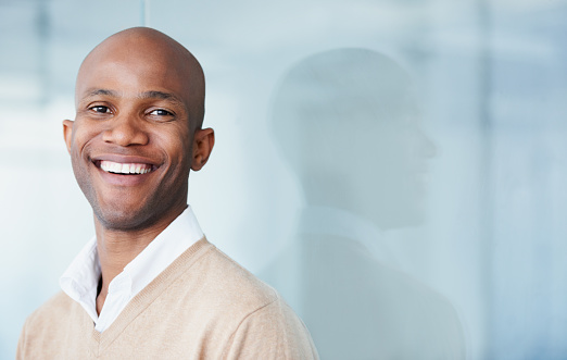 Young black man smiling with veneers with blue background at San Francisco Dental Arts in San Francisco, CA Young black man smiling with veneers with blue background at San Francisco Dental Arts in San Francisco, CA