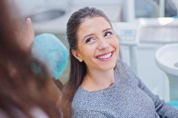 Woman smiling and receiving an oral cancer screening at San Francisco Dental Arts in San Francisco, CA
